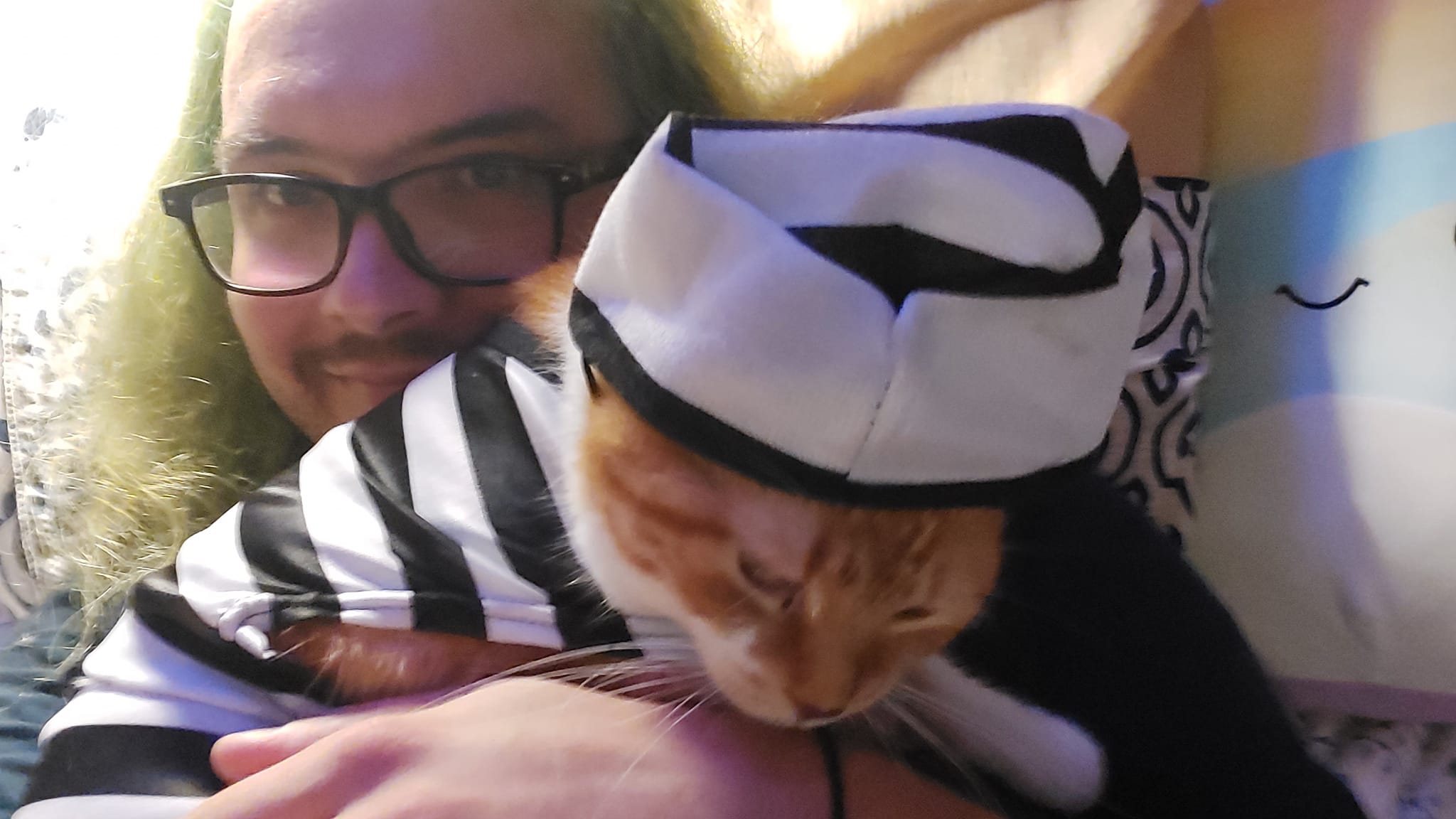 A man with long green hair and no beard holds an orange cat, the cat is dressed as a 1930s prisoner, Photo 2